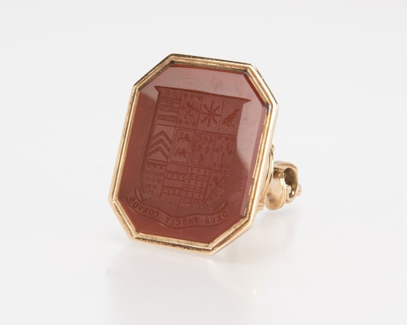 An antique gold and carnelian fob seal: Tests 14K yellow gold, the carnelian seal measuring 1 1/4'' x 1'', 25.3 grams, est: $300/400 Note: The motto ''Deus pascit corvos'' (God feeds the ravens) indicates the seal was likely made for a memb