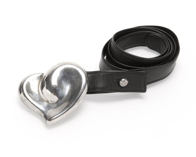 A silver belt, signed Elsa Peretti, Tiffany & Co.: The sterling silver heart-shaped buckle signed "Italy, Elsa Peretti, 1978", with a black leather strap, est: $150/200