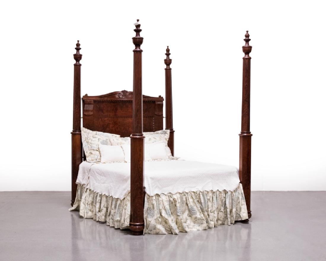 Mahogany Empire-style four-poster plantation bed: Second quarter 19th century, each widening octagonal post topped with a turned urn-form finial, the scrolled and wave-molded backboard over carved supports, on turned circular feet, 102.5'' H x 71.75'