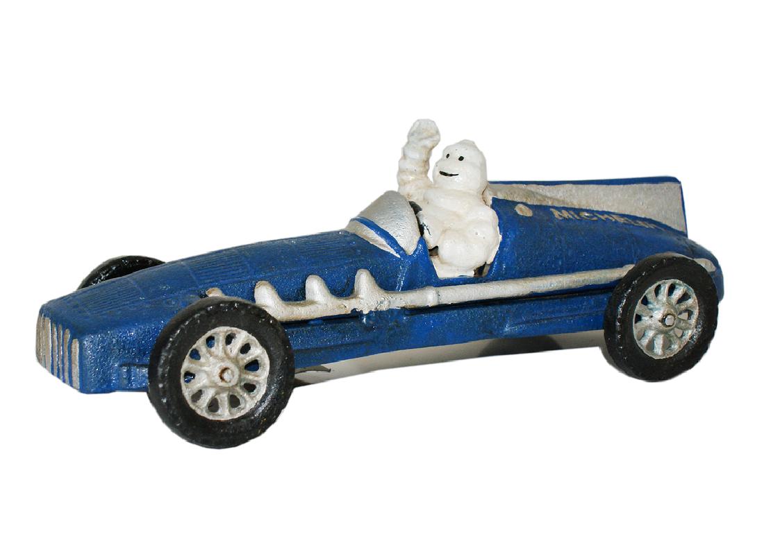Michelin Man Race Car' figure.: Michelin Man Race Car' figure. Made from cast iron. Height 7.5cm Width 10cm Depth 25cm.