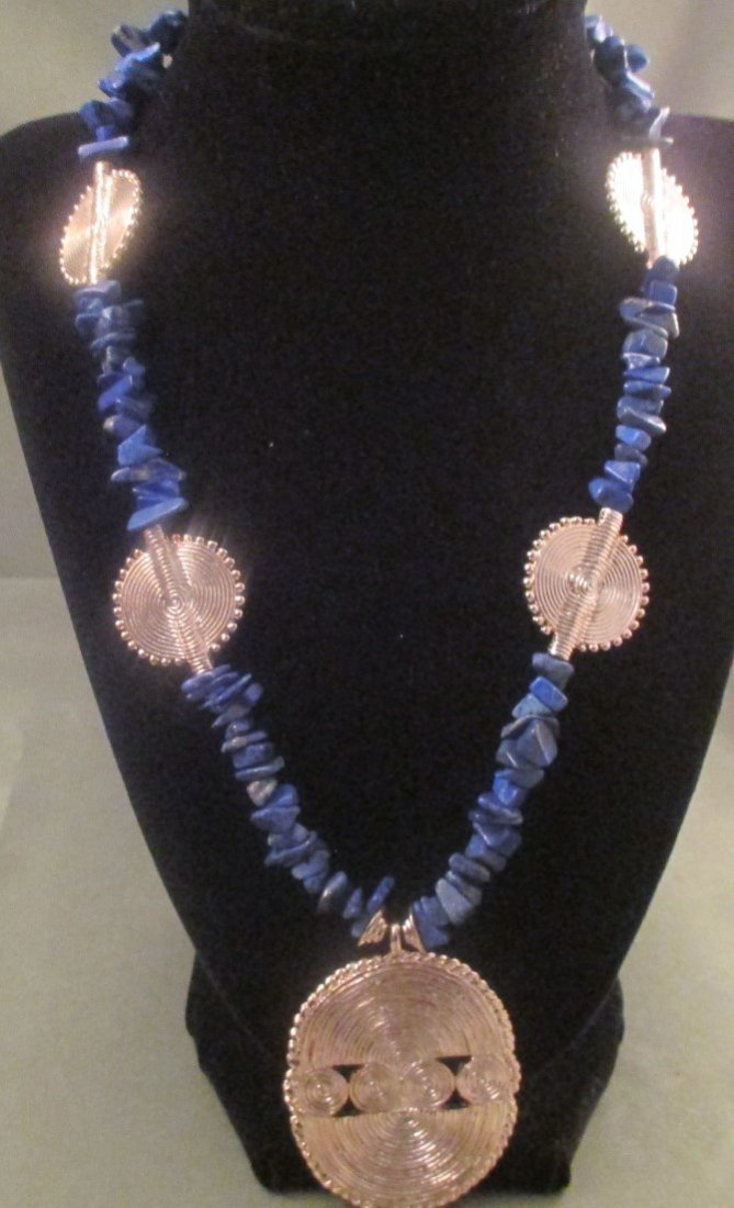 Mary McFadden Blue Nugget Goldtone Necklace: Mary McFadden Blue Lapis Nugget Bead and Gold Tone Necklace. Necklace Measures 20" Plus A 4" Extender. The Clasp Is A Fancy one Where The one end slide into the other circle. This is a beautiful neckl