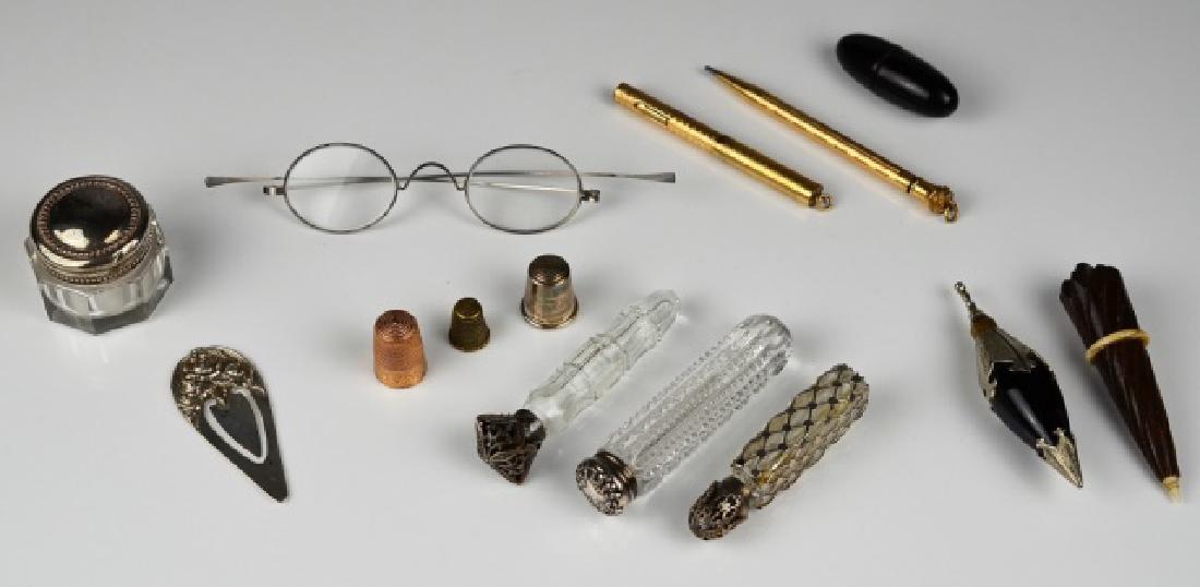 LOT OF ANTIQUE DRESSER & DESK PIECES: Including an English .9k rose gold thimble 4.6g, antique needle cases, glass perfume flasks with silver and plate caps, a Kirk & Sons silver bookmark and gold filled pens.