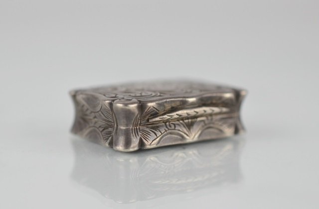 VICTORIAN SILVER VINAIGRETTE: Decorated with scrolled foliate exterior and gilt wash interior by Edward Smith, Birmingham. 13 grams.