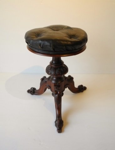 VICTORIAN WALNUT PIANO STOOL: With carved fruit on legs and scroll feet and original material on top (small tear). Ht. 19 in.