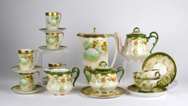 HAND PAINTED PORCELAIN TEA AND COCOA SETS: Cocoa pot with 5 demi-tasse with Art Nouveau decoration, tea set with tea pot, trivet, cream and sugar, 2 cups & saucers by Reinhold Schligelmilch Tillowitz. Ht. of cocoa pot 23.5 cm. (9.25 in.)