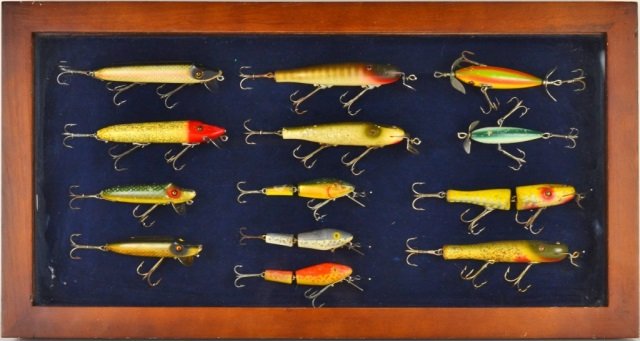 COLLECTION OF VINTAGE FISHING LURES: 13 lures total in display case including old wooden Heddon, Pflueger, Lucky Strike, L & S Minnows, etc.