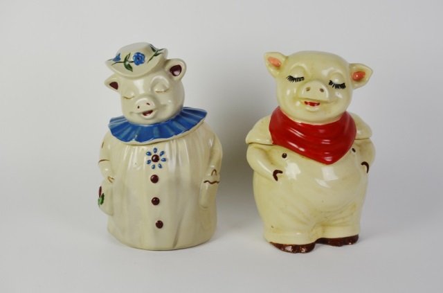 TWO SHAWNEE FIGURAL PIG COOKIE JARS: Pig with red scarf has minor paint loss. Signed USA to base. Pig with floral decoration is signed Shawnee to base. Ht. to tallest 30.5 cm. (12 in.)