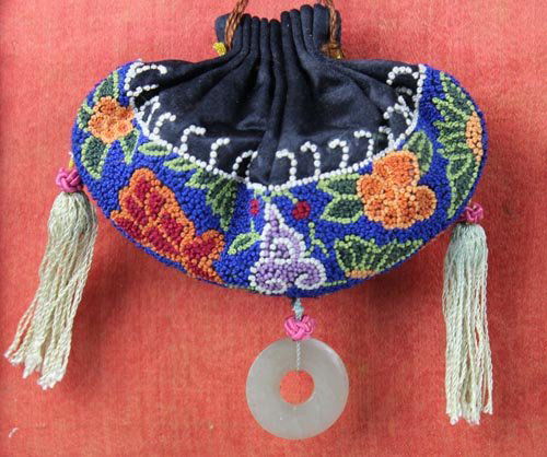 A Chinese Embroidered Silk Purse. Qing Dynasty: In kidney bean shape, with drawstring embellished with jade and hard stone beads, further adorned with tassels and a jade ring. Now attached on a frame for display. Circa late 19th century. H：