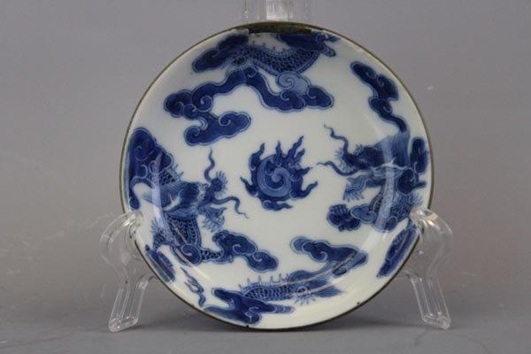 A Rare Imperial Bleu de Hue Blue and White Chinese: Elaborately painted in vivid cobalt blue on the exterior and interior with five-claws dragons chasing a flaming pearl amid clouds. The base bears four imperial characters mark reading Noi phu thi trun
