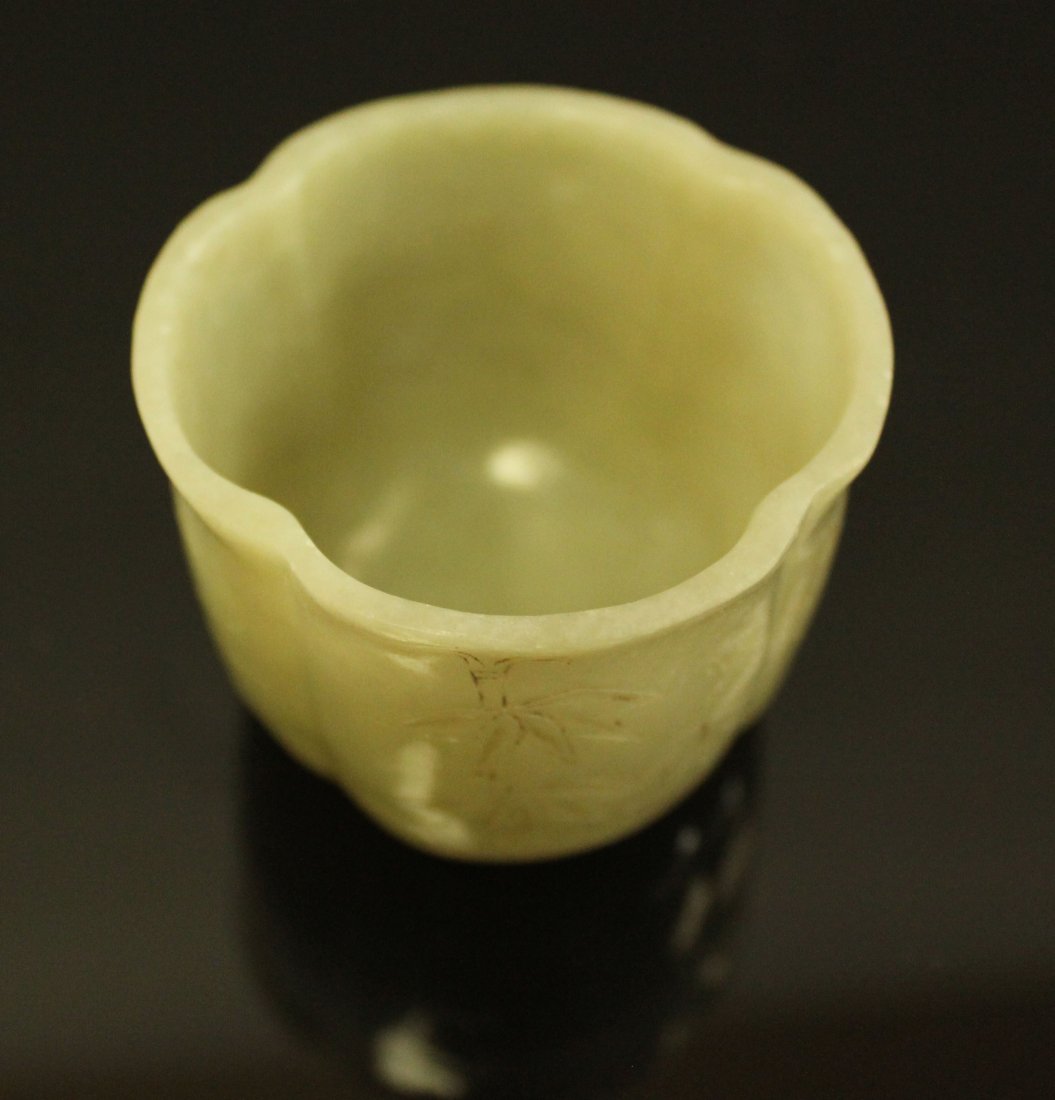 A Very Rare Chinese Carved Jade Wine Cup. Qing Dynasty: Carved from a single block of celadon jade into a floriform cup with lobbed wall, foliated rim and quadrofoil footring. The exterior wall further decorated with incised flowers of four seasons. The ba