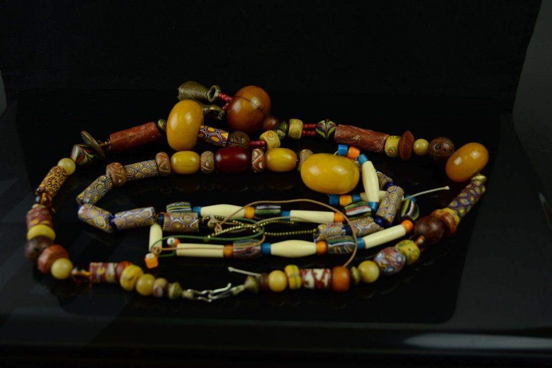 Collection of 3 Baltic amber necklaces: Antique African and West Asia style necklaces with large, bulbous Baltic amber beads alternating with smaller beads of various material, including etched glass in tubular forms, glass, amber and Balti