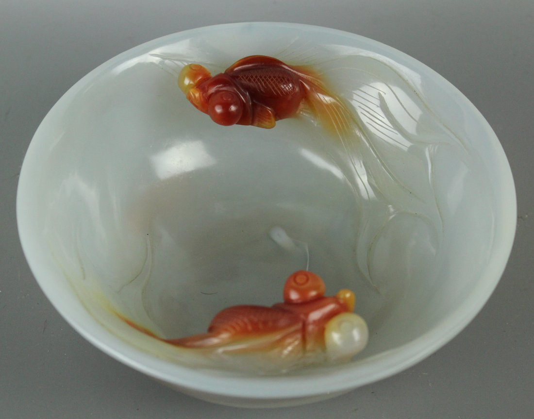 A Large Chinese Carved Agate Bowl With Goldfish: Carved from a single block of watery white agate with some carnelian inclusions, which have been cleverly incorporated to depict two goldfishes with bulging eyes and long tails on the cavetto. 18x6.3c