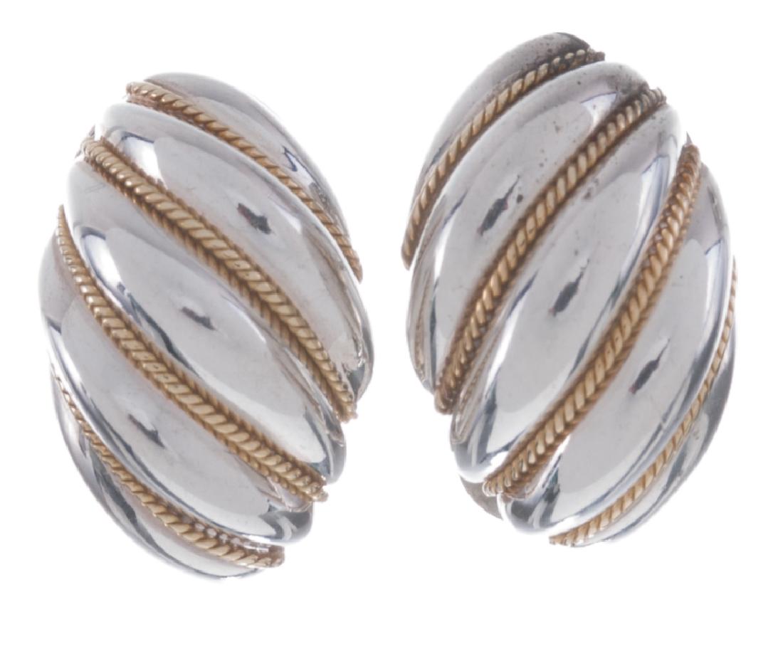 Tiffany & Co. Sterling & 18K Swirl Earrings: Classic Tiffany omega back shrimp swirl earrings for pierced ears in sterling silver with 18k yellow gold rope swirl accents, 3/4" in total length and stamped "Tiffany & CO .925-750" to the back of ea