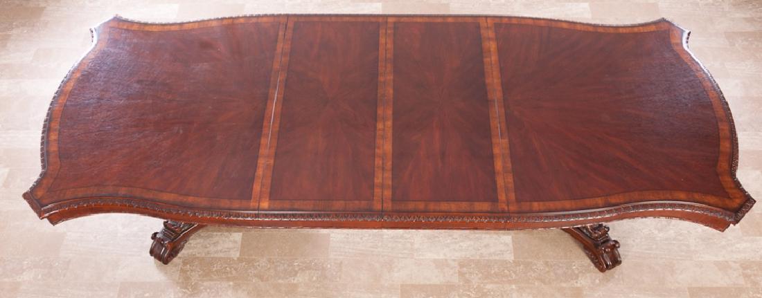 French Library, Conference, or Dining Room Table: Continental style banquet table having string and banded inlay to the top, foliate carvings to the apron, all resting on two tapered triangular pedestals having applied acanthus carvings and scrolled 