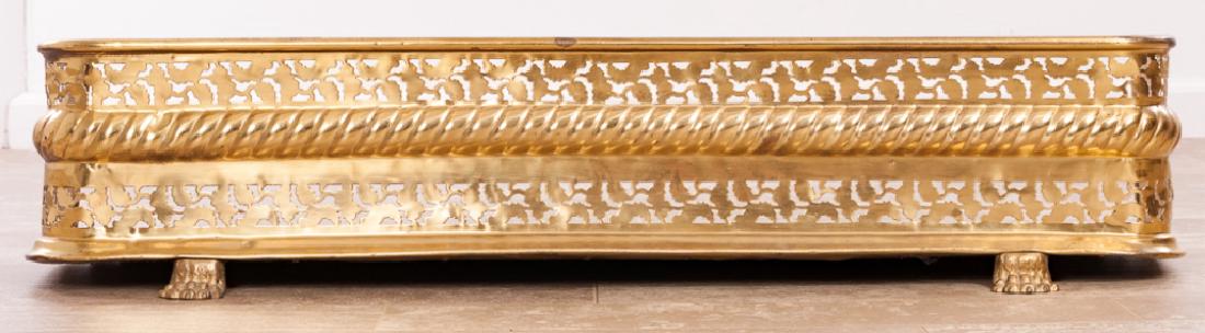 Brass Fireplace Fender: Pierced and cable designed brass fireplace fender resting on paw feet; measures approximately 8-1/4" tall, 39" wide, and 12-1/2" in depth.