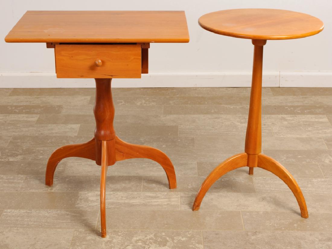 Benchcrafted Occasional Stands Duo: Two (2) mixed wood occasional stands. One stand having a round top and tripod feet; measures 26” high and 16-1/4” in diameter. The other, a square top stand with a single drawer, resting on tripod