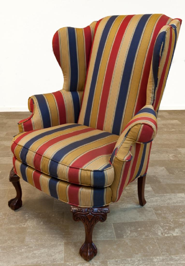 Upholstered Wingback Chair: Striped upholstered wingback chair having a tall back, rolled arms, and carved front legs ending in ball and claw feet; measures approximately 47” high by 38" wide with a seat depth of 20" and a sea