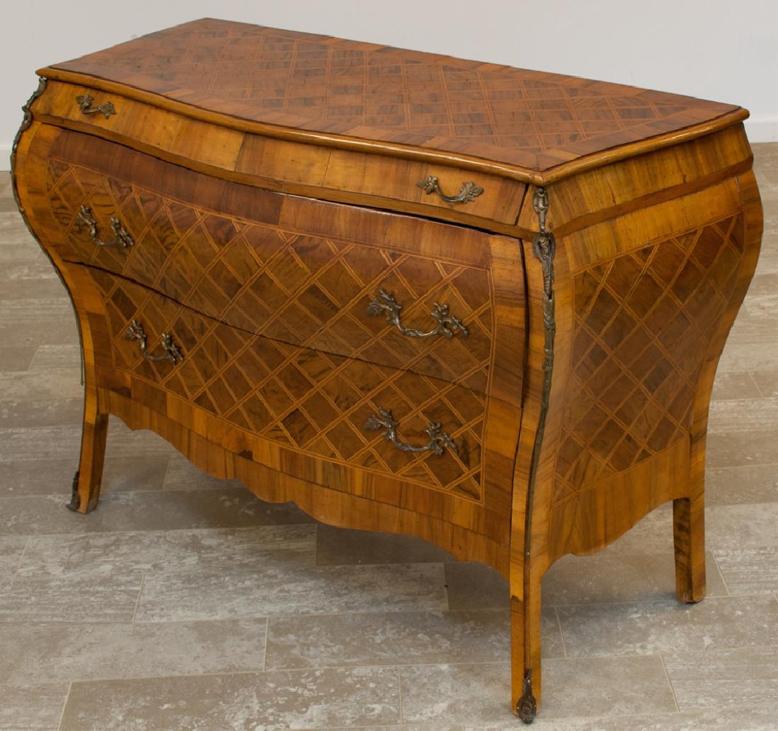 Louis XVI Style Bombe Commode: Louis XVI style bombe commode having all over inlays, ormolu mountings, scroll apron, and three drawers; measures approximately 31-3/8" high, 45-3/8" wide and 18" deep.
