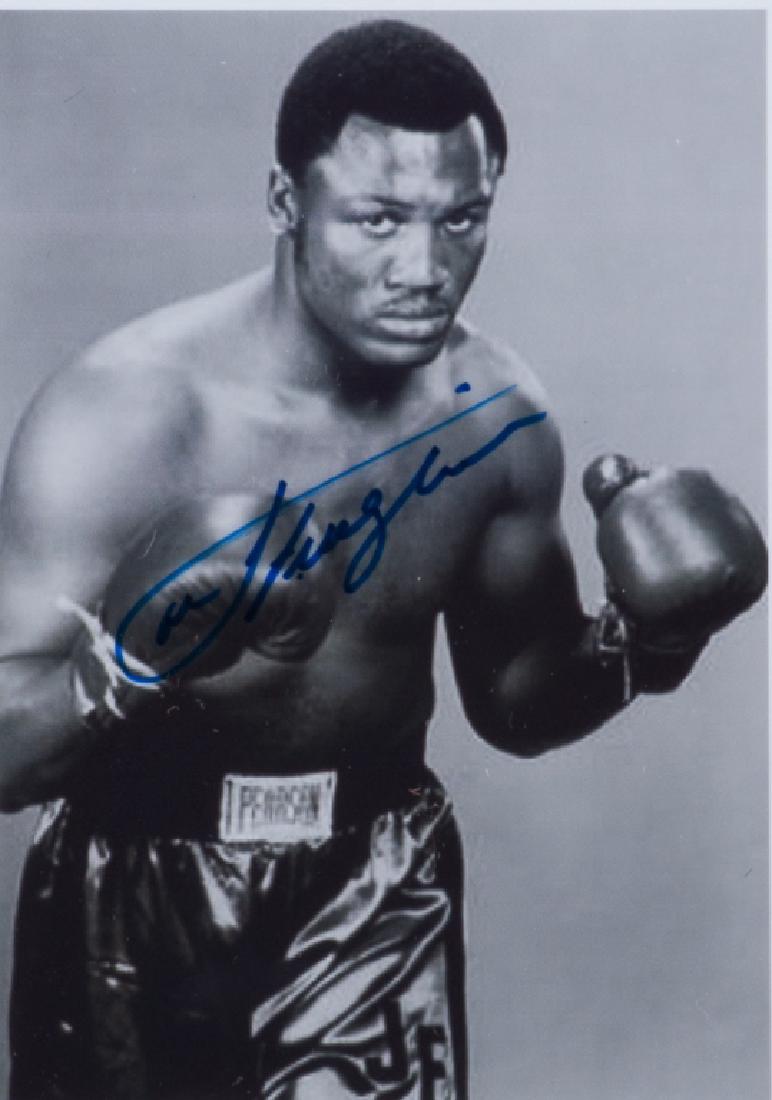 Smokin' Joe Frazier Autographed Framed Photograph: Framed and matted under glass photograph of and signed by heavy weight champion "Smokin Joe" Frazier With PTC certificate of authenticity on the back. Frame measures approximately 12" in height by 10"