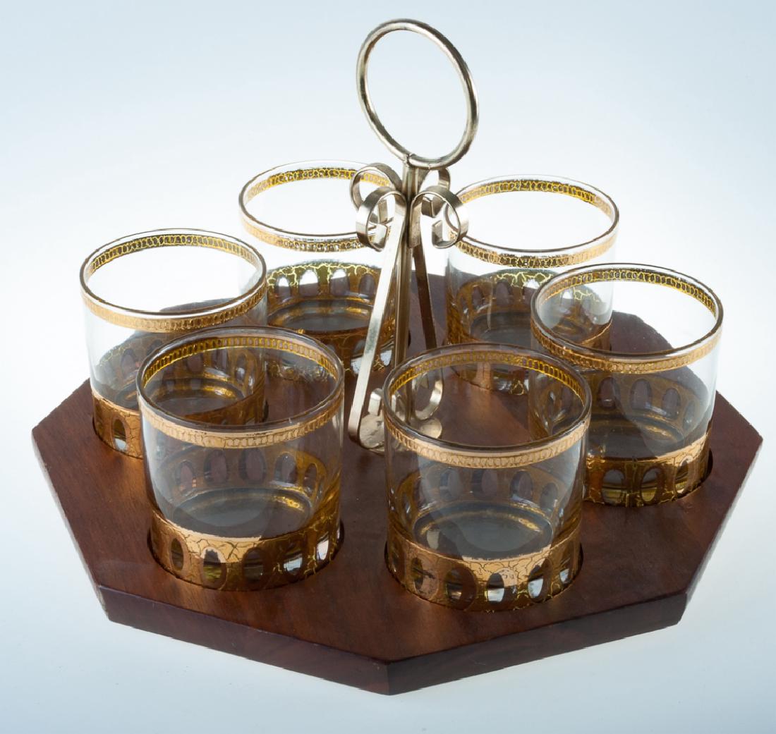 Culver Double Old Fashion Rocks Glass Set: Circa 1960’s set of six Culver Ltd. double old fashion rocks glass with 22-karat gold decoration and a hexagonal wood base tray with gold toned handle. Glassware marked Culver Ltd. Glasses measure 3