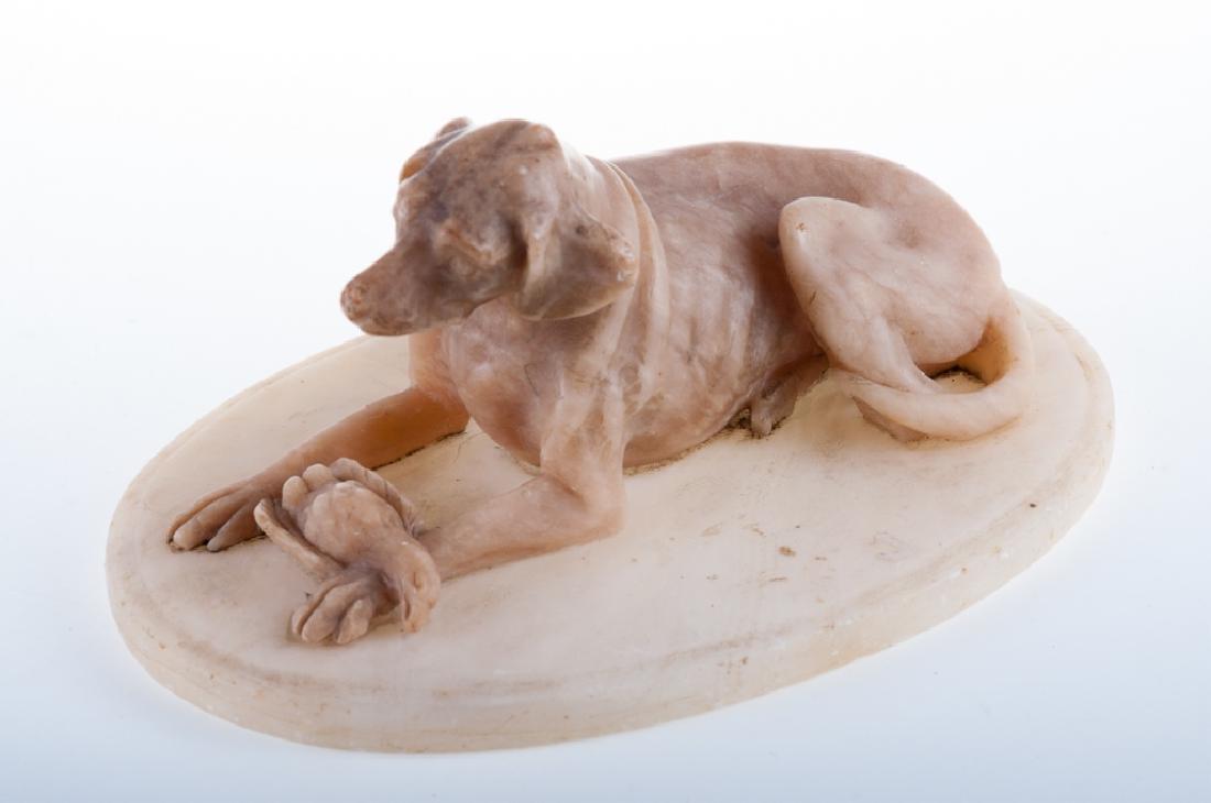 Alabaster Sculpture of Hunting Dog: Alabaster sculpture of a hunting dog, reclining with a dead bird across the front legs, on an oval base. Measures approximately 2-3/4" high, 5-3/4" long.