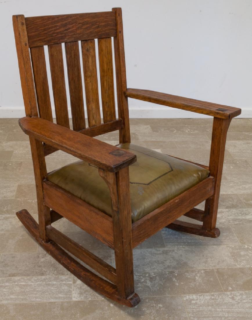 Arts & Crafts Tooled Leather Seat Rocking Chair: Early 20th Century oak rocking chair having pegged construction, a slat back, and tooled leather seat, unmarked, measures approximately 35-1/4" high, 27-3/4" wide, seat depth of 16-1/2", and a seat he