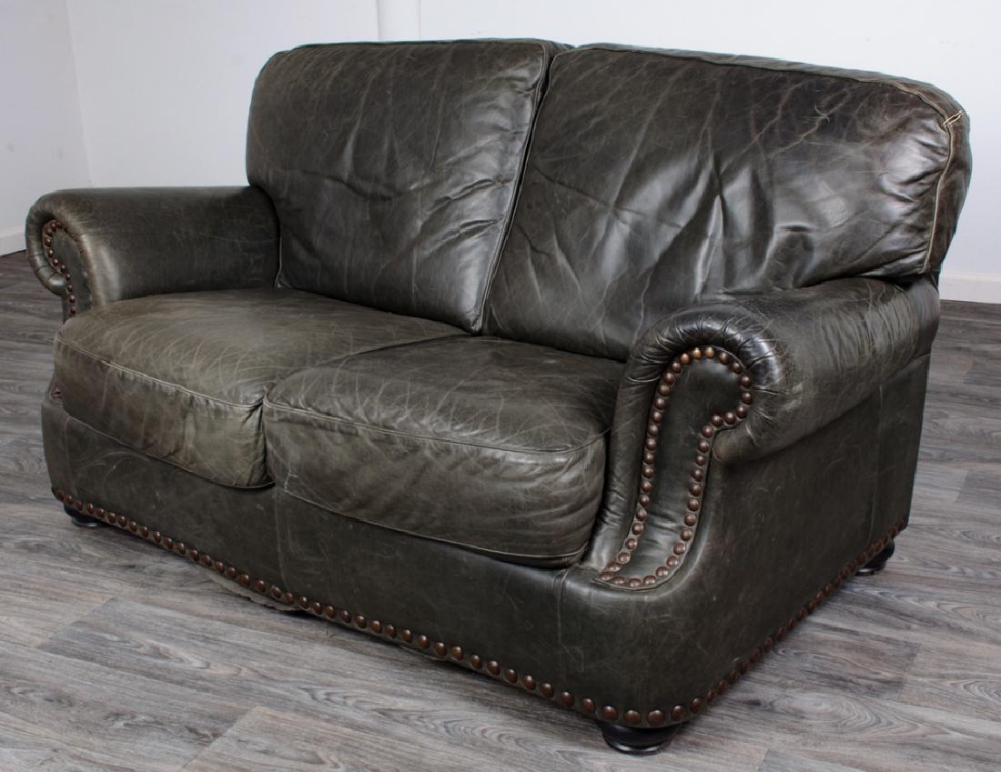 Leather Loveseat: Green distressed leather loveseat having rolled arm rests, nailhead accents, all resting on bun feet; measures approximately 32" high, 66-1/2" wide, total depth of 34" with a seat depth of 21-1/4" and