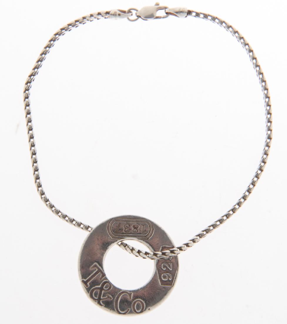 Tiffany & Co 1837 Disc on SS Chain Anklet: Tiffany & Co. circle disc stamped T&Co 925 1837 to one side. On a squared silver chain. Chain measures 10" in length, with a lobster claw clasp and is stamped 925 Italy. Weighs approximately 0.65 oz t