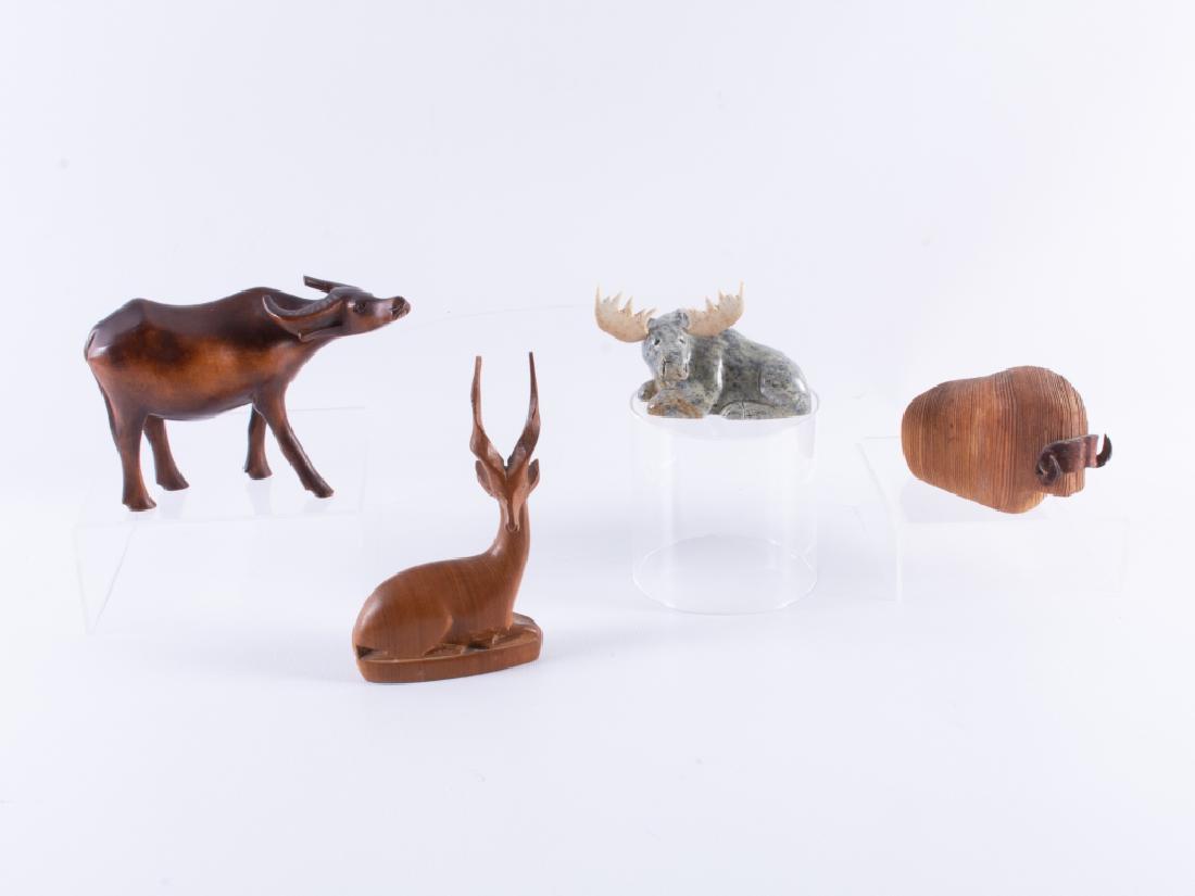 Carved Animal Figures Group: Carved animal figures, three of wood, including a water buffalo, a reclining antelope, a musk ox with leather horns, and a reclining moose carved of soapstone with bone antlers. Antelope measures appr