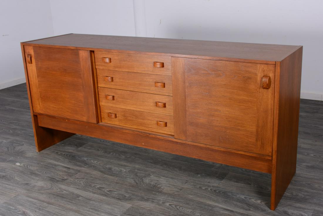 Domino Mobler Teak Sideboard: Domino Mobler teak sideboard with the center section having four drawers and flanked by sliding doors covering shelves. Marked to the back. In good overall condition consistent with age and use. Measu