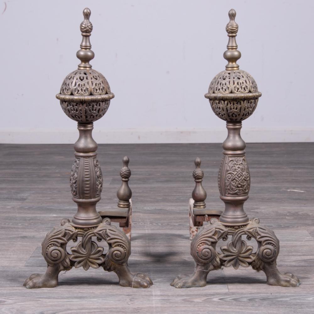 Pair of Continental Brass Andirons: With filigree balls and baluster finials, molded baluster columns, pierced bases and paw feet. Measures approximately 22-1/2" high, 10-1/2" wide, 19-1/2" deep. All sales are subject to Bremo Auctions 