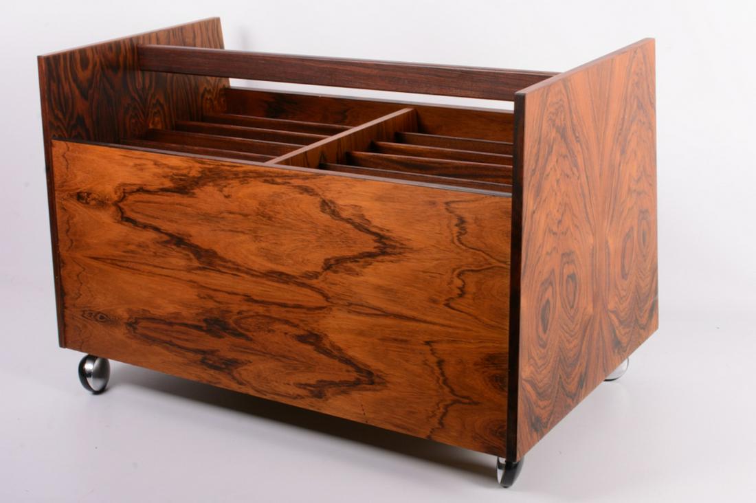 Rolf Hesland Rosewood Canterbury: On casters designed by Rolf Hesland for Bruksbo of Norway. Paper labels to the bottom. In overall good condition consistent with age and use. Measures approximately 17-1/2” high, 26-3/4” wide, and