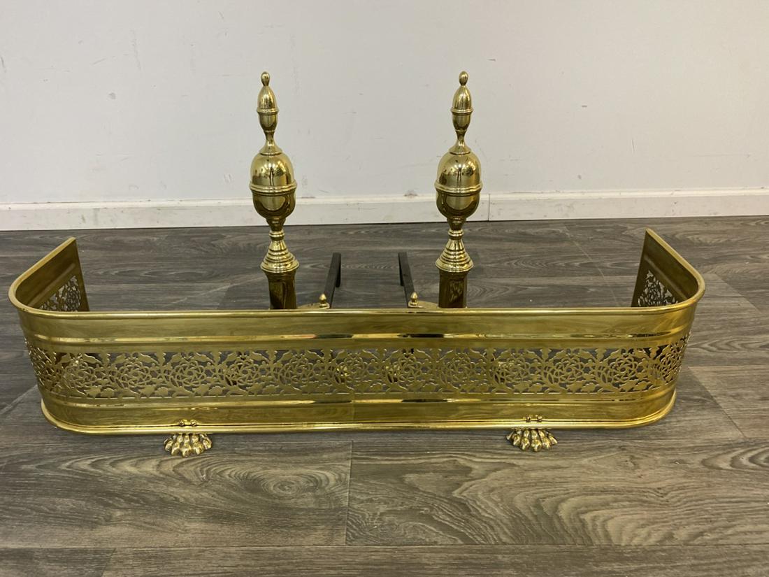 Pair of Brass Andirons and Fire Fender: Andirons measure approximately 21-1/4" high, 9-1/4" wide and 16-6/4" deep. Fire fender measures approximately 9-1/4" high, 42-3/4" wide and 12-1/4" deep. All sales are subject to Bremo Auctions Terms 