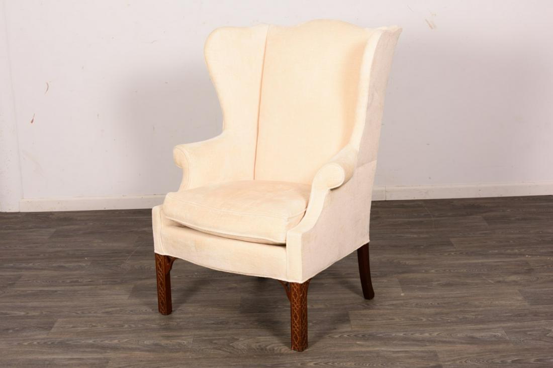 Upholstered Wingback Chair: Off white upholstery on square feet. Measures approximately 46" high, 31" wide and 24" deep. All sales are subject to Bremo Auctions Terms & Conditions. Please review before bidding.