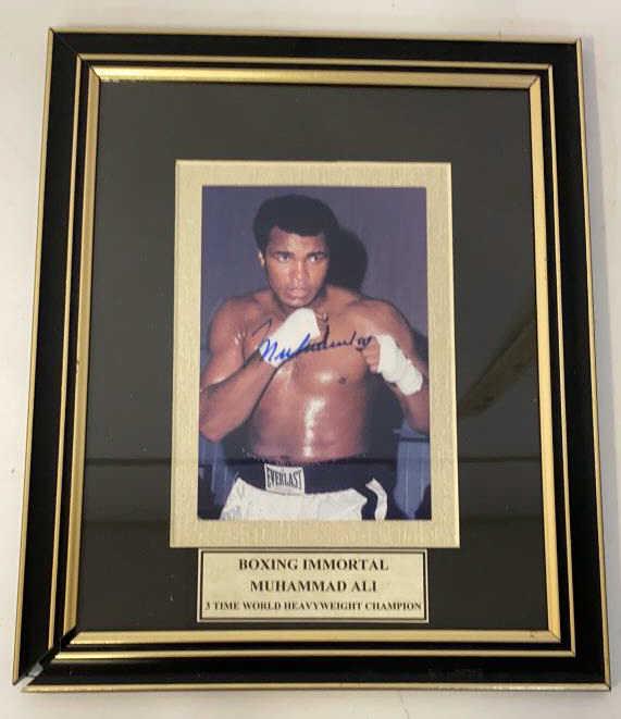 Muhammad Ali Signed Photo: Muhammad Ali "Boxing Immortal" photo. Signed. Matted and framed under glass. Measures approximately 11-5/8" in height by 9-5/8" in width.