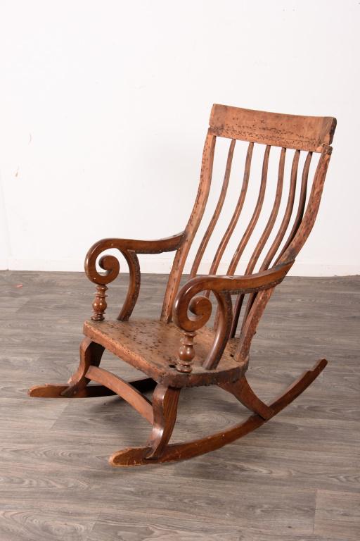 E 19th C Rocking Chair: Probably Louisiana, with a curved spindle back, curved crest, scrolled arms with turned supports, and flat rockers. From the private collection of Roulhac Toledano, noted author, historian, artist, an