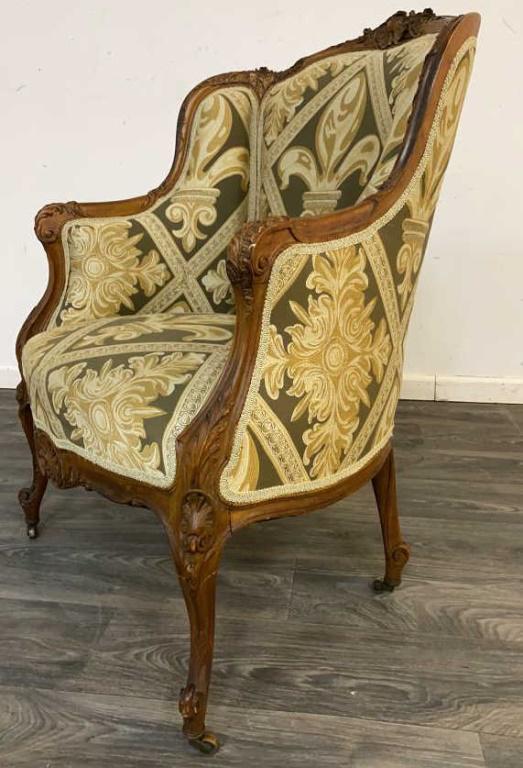 French Bergere Chair: French Bergere chair reupholstered in French Fleur de lis fabric. In overall good condition consistent with age and use. Measures approximately 40" high. 29" wide and 24" deep.
