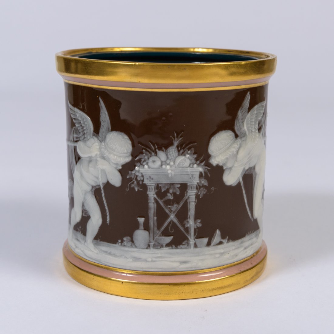 A Mintons Pate sur Pate Porcelain Jar,: with a signed Alboin Birks design of cherubs pulling a rope on brown ground trimmed in pink and gold, with a dark blue interior. Missing the lid. 4 1/2" high.
