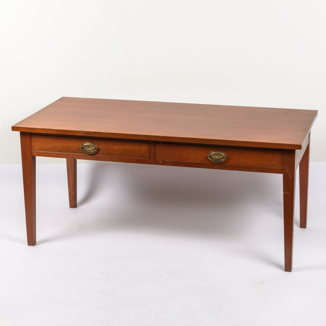 A Cherry Two Drawer Coffee Table: With tapered legs. By Davis Cabinet Makers of Charlottesville, Virginia. Height: 19" Width: 42" Depth: 20"