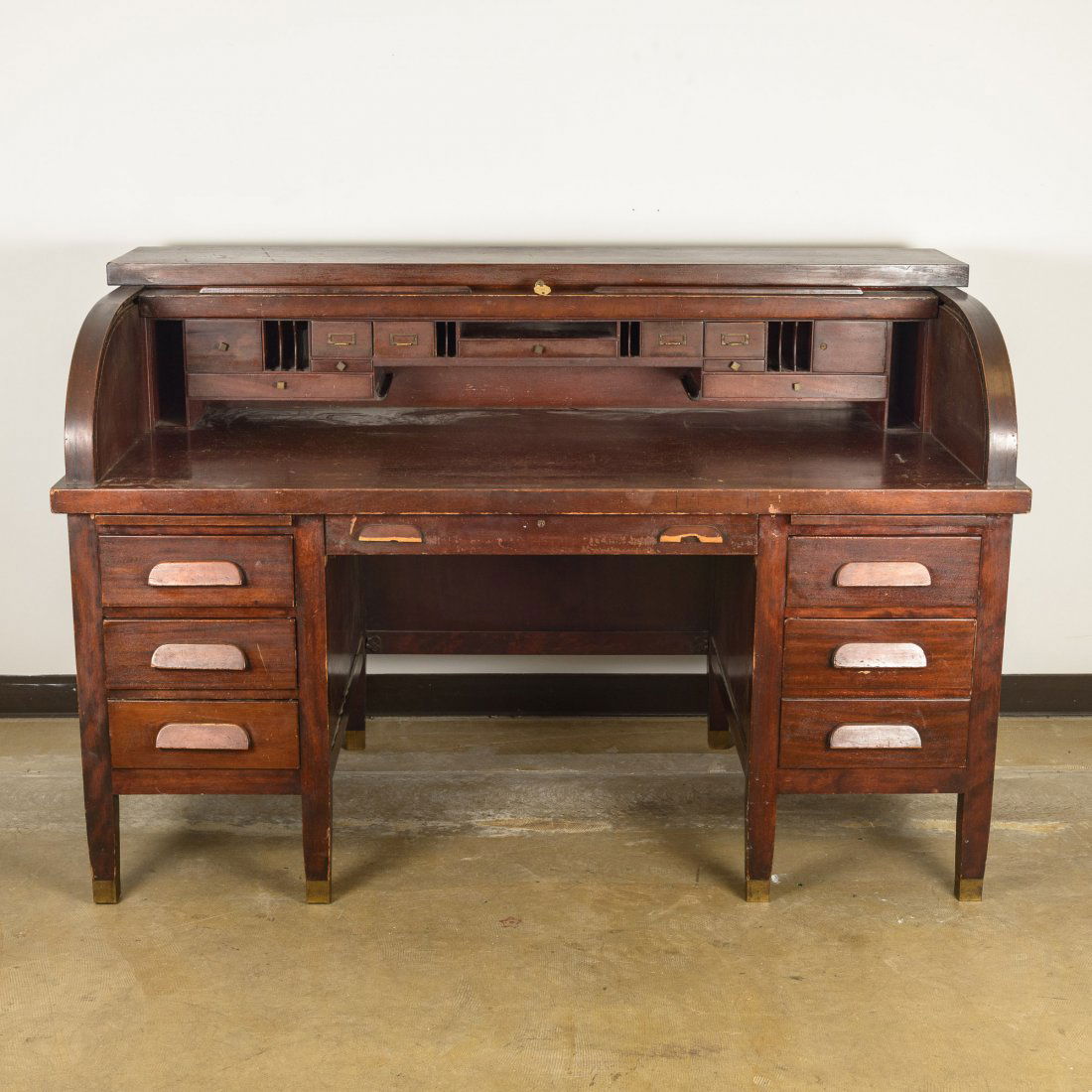 A Roll Top Desk with Office Chair: Having two side columns each with three graduated drawers, and eleven internal drawers. Height: 43 1/2" Width: 66" Depth: 34 1/2"