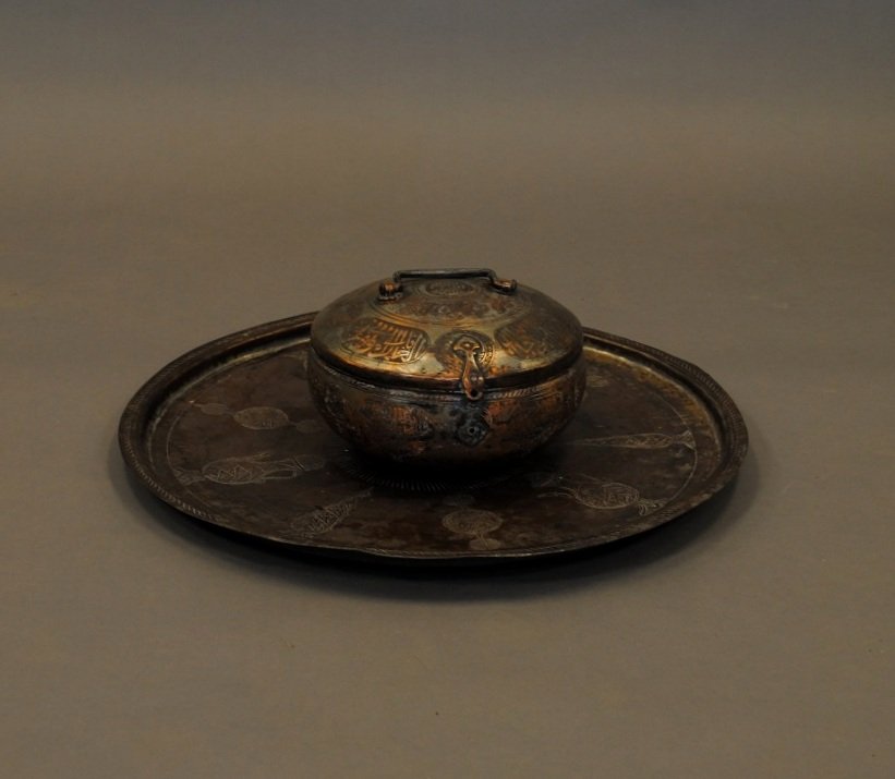 A Middle Eastern Brass Tray and a Lidded Bowl: Bowl has inscriptions in Arabic. Tray has geometric designs. Tray diameter: 21 1/4" Bowl height: 5 1/2" Diameter: 9 1/2"