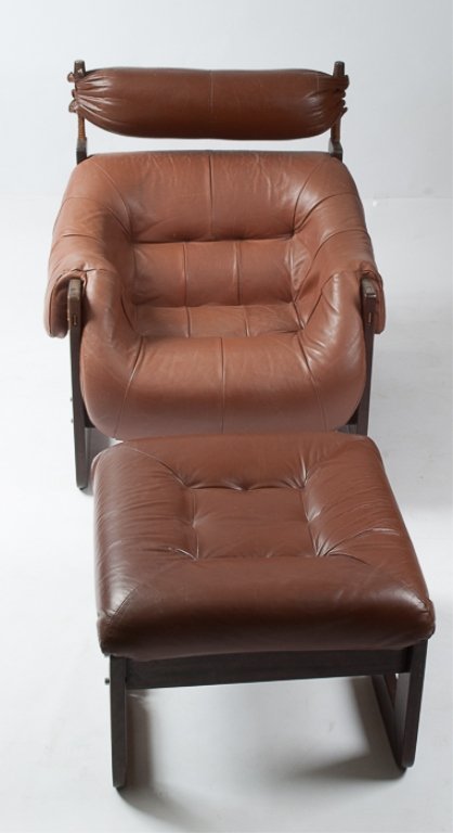 "Percival Lafer" Lounge Chair and Ottoman: Made of rosewood and brown leather; chair measures approximately 35" tall to top of back, 30-1/2" wide from arm to arm, and 20-1/2" deep from back of seat to front; ottoman measures approximately 16" 