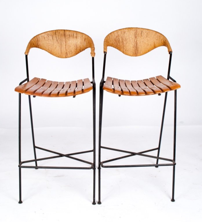 Pair of Umanoff Bar Stools: Measures approximately 40-1/2" tall, 18" wide, and 14-1/2" deep; black metal frame; wood panel seats and wicker back; a nice pair; apparently in good condition.