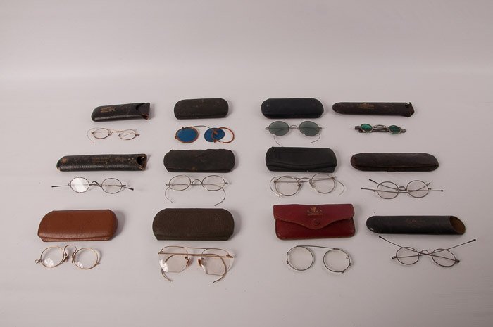 Collection of Twelve (12) Vintage Eyeglasses: Also includes twelve vintage eyeglass cases; includes among others, a pair of green glass eyeglasses, and a pair of dark glass eyeglasses; several are broken.