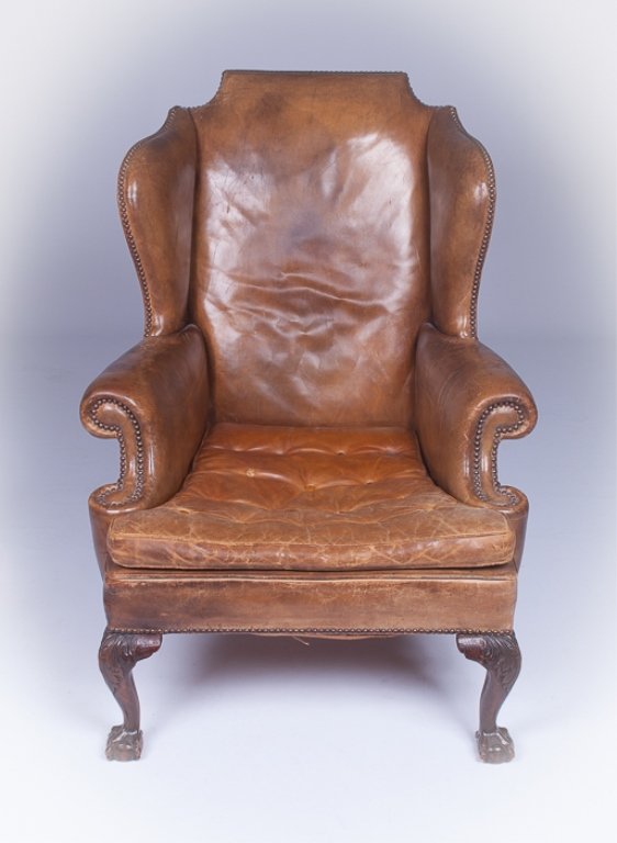 Brown Leather Chippendale Style Wingback Chair: Nicely stressed brown leather Chippendale style wingback chair with a nail head trim, buttoned seat, and clawed feet; measures approximately 44-1/2" tall to top of back, 17-1/2" tall to top of seat, 3