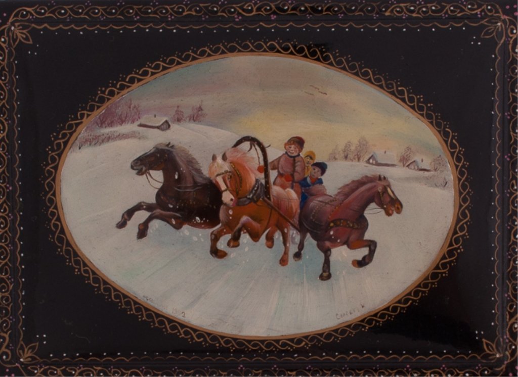Fedoskino Russian Lacquer Box: Depicting Russian Troyka on hinged lid and painted red to inside; dated 1993; signed by artist Sergeer; gilded floral edging; measures approximately 1-1/2" tall, 5" wide, and 3-1/2" deep.