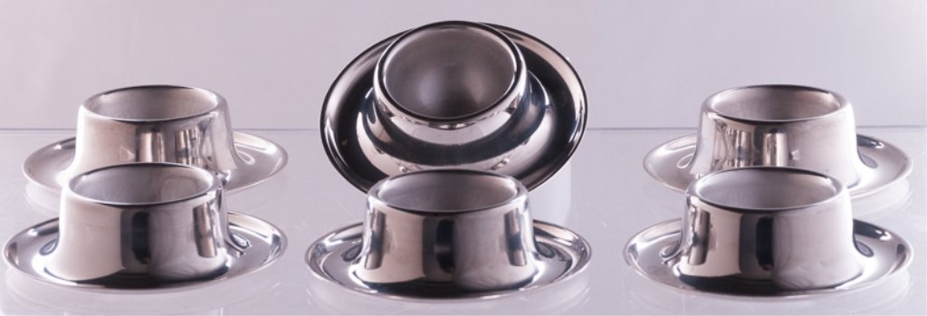 Württembergische Metallwarenfabrik Egg Cups, Six: Six Württembergische Metallwarenfabrik stainless steel egg cups; marked to bottom "18/10 Germany"; measures approximately 1" tall and 3-1/2" in diameter.Württembergische Metallwarenfabrik (or WMF AG