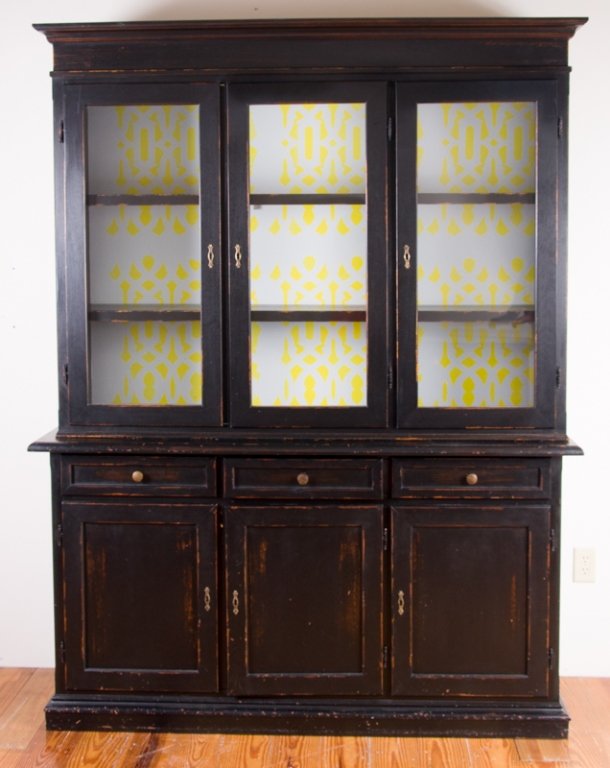 Refurbished Modern China Hutch: Black painted refurbished modern china hutch featuring three glass front cabinet doors to top that houses two unit wide shelves with yellow design on white background backing to cabinet; keyholes to m