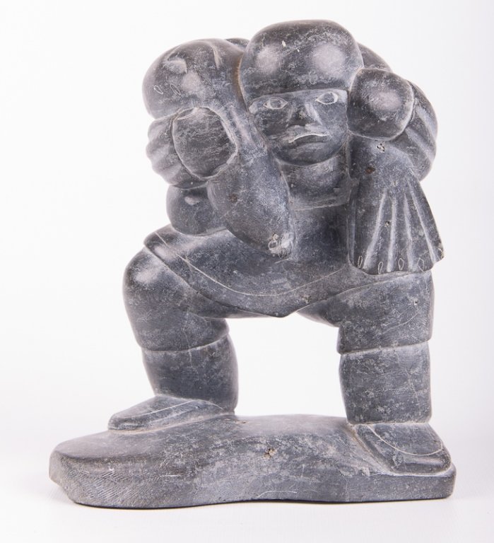 Silas Kayakjuak Inuit Stone Figural Carving: Silas Kayakjuak (Qayaqjuaq; Inuit; Hall Beach, Nunavut Territory, Canada; 1956-) Inuit soapstone figural carving; labeled to bottom "Canada Eskimo Art" and etched to bottom "212104"; unsigned; measure