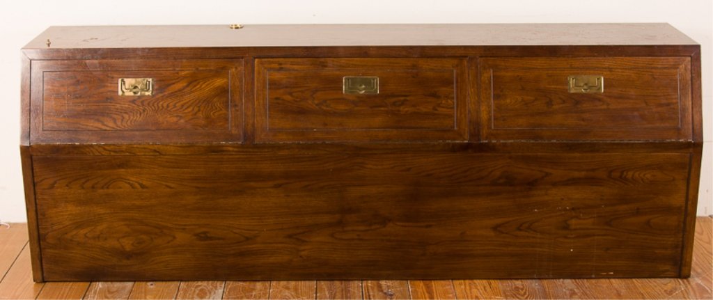 Henredon Campaign Style King Size Headboard: Henredon campaign style headboard with three fold-down cabinet doors housing large storage compartments; walnut with brass handles; measures approximately 28-1/4" tall, 80" wide, and 18" deep; in Fair